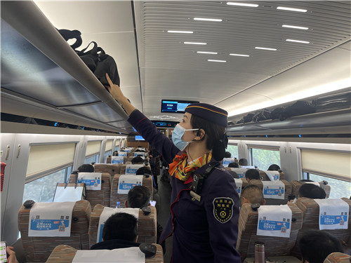 广九客运段京广动一车队列车长杨辉燕巡视车厢，整理行李架上的行李  拍摄者：刘利萍.JPG