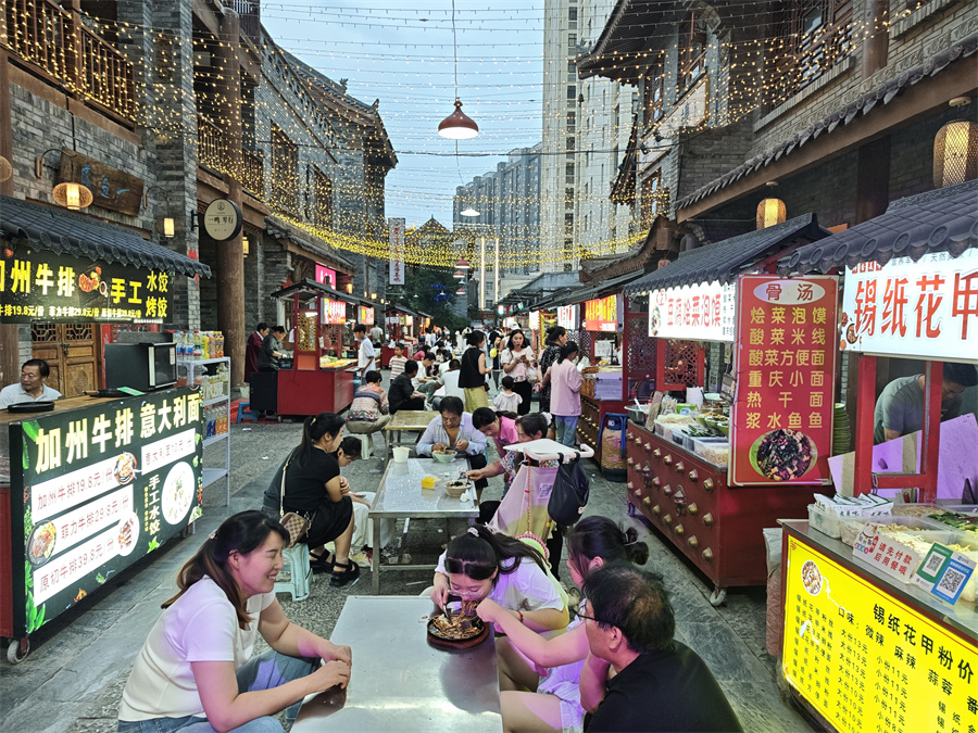7月1日晚，洛南县花溪弄夜市，市民和游客在品尝小吃。（张帆摄）.jpg