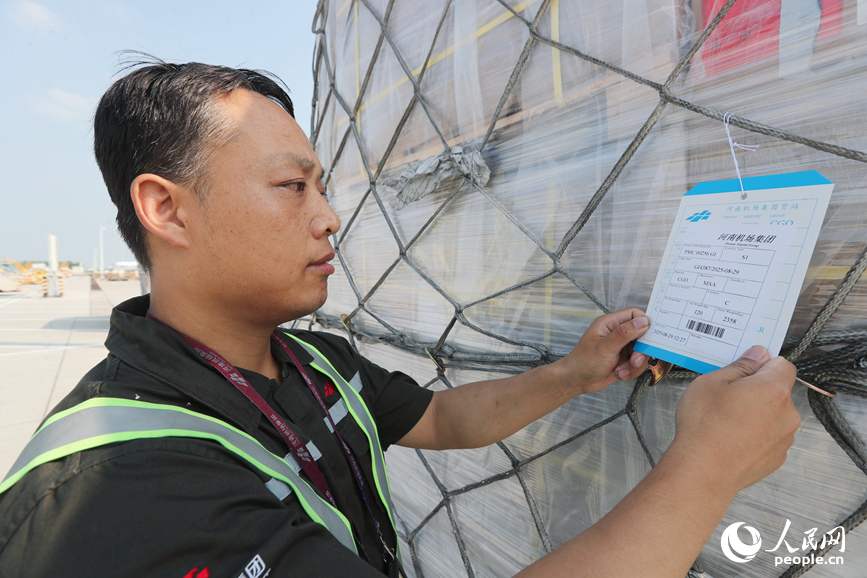 郑州新郑国际机场，工作人员对出口货物进行信息核验。人民网 霍亚平摄