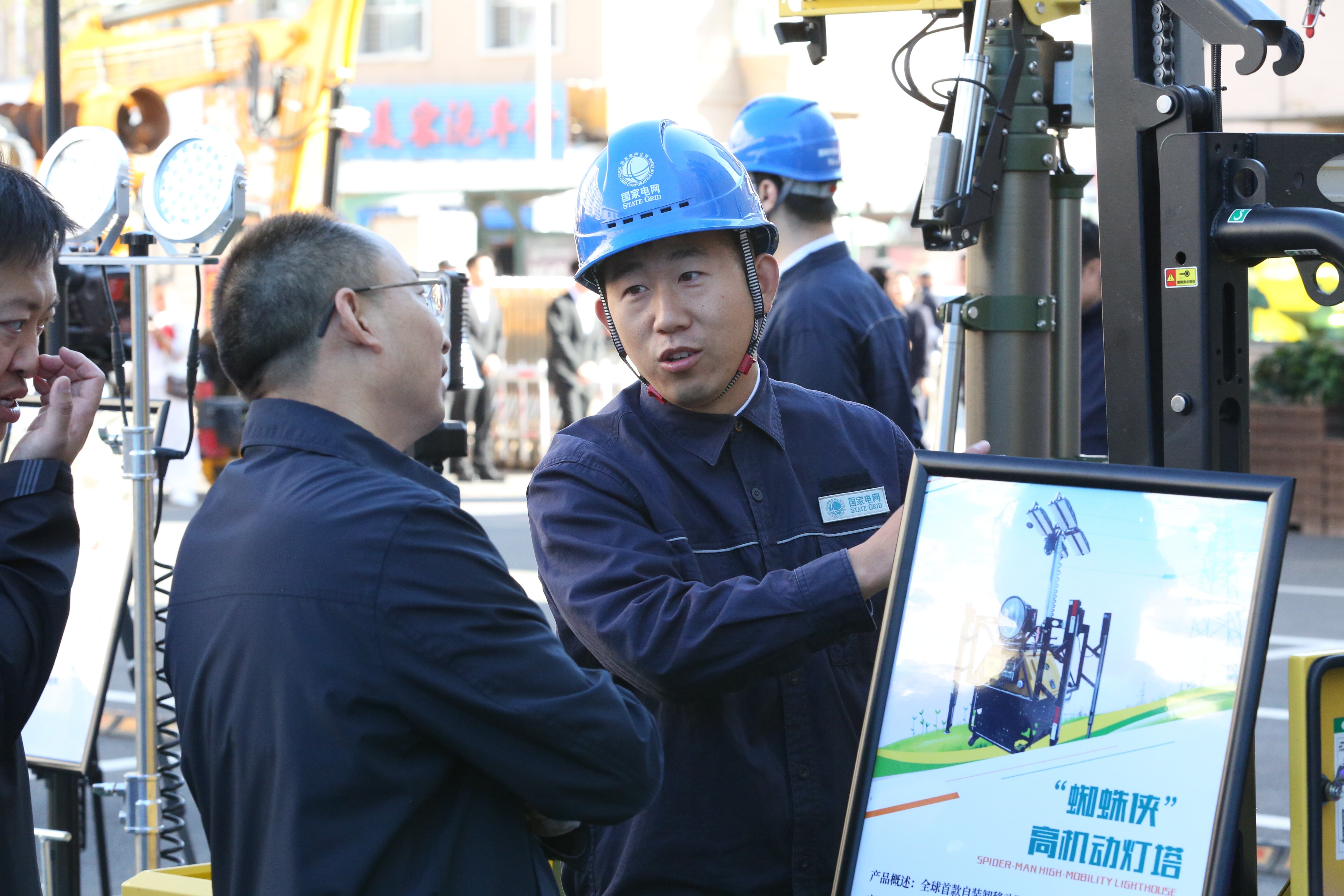 9月26日，国网齐齐哈尔供电公司员工王春阳向活动来宾介绍高机动灯塔1计宏摄.jpg