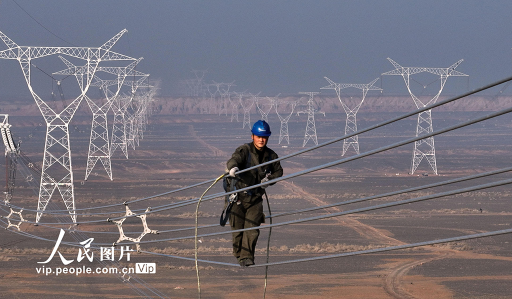 新疆奇台：电力员工高空走线消缺