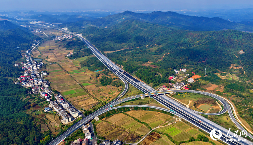 沪昆高速昌傅至金鱼石(赣湘界)段改扩建项目施工现场机械轰鸣,工人在摊铺路面沥青。人民网记者 朱海鹏摄