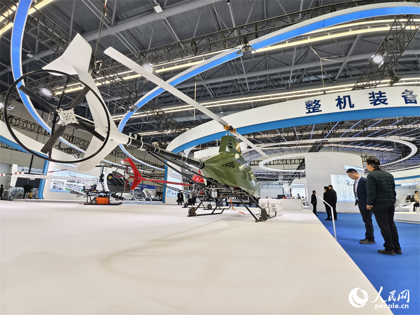 景德镇低空产业生态展上，人们在整机装备区参观一架无人直升机。人民网记者 时雨摄