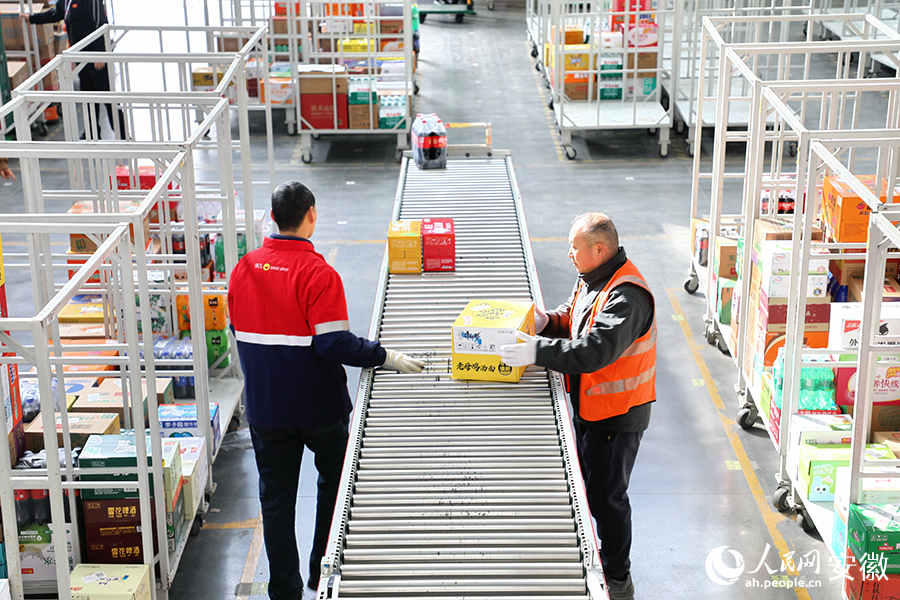 合肥及养食品有限公司内，工人们正在挑选打包货物。人民网 郭昊摄