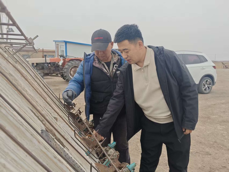 1779431977956024.jpg 农业技术人员查看农机情况.jpg