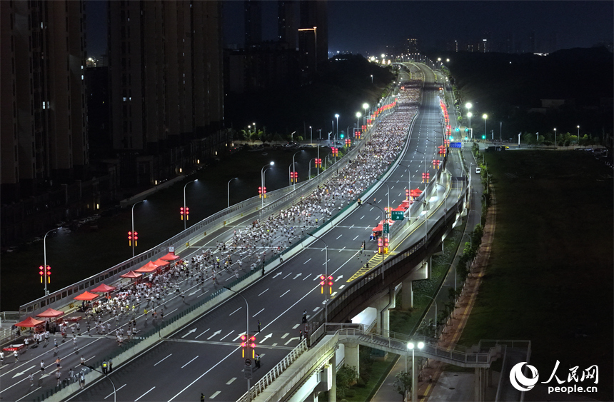 2026南昌万人夜跑活动30日晚鸣笛开跑。图为跑友奔跑在洪州大桥上。人民网记者 时雨摄
