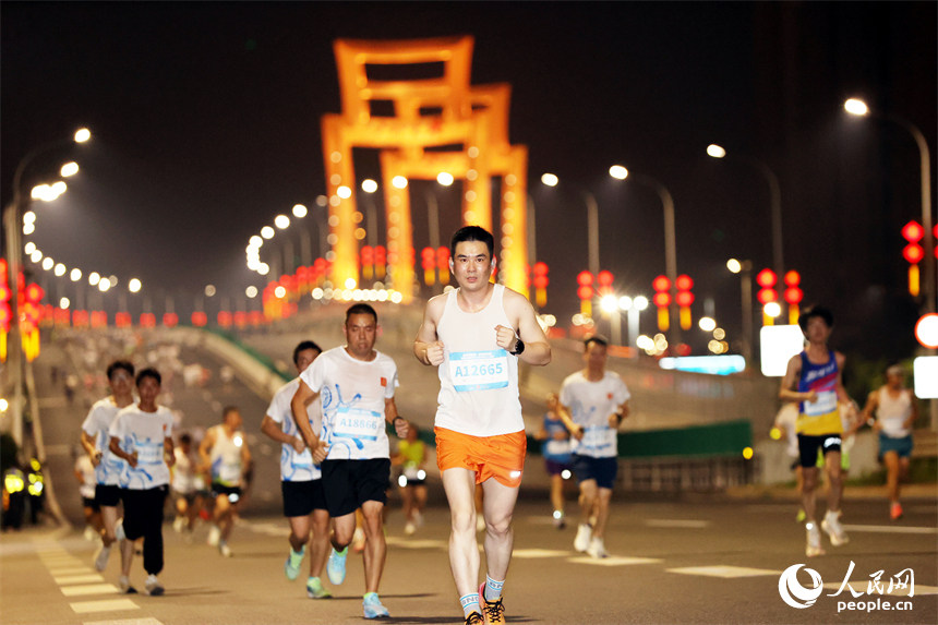 2026南昌万人夜跑活动30日晚鸣笛开跑。图为跑友奔跑在洪州大桥上。人民网记者 时雨摄