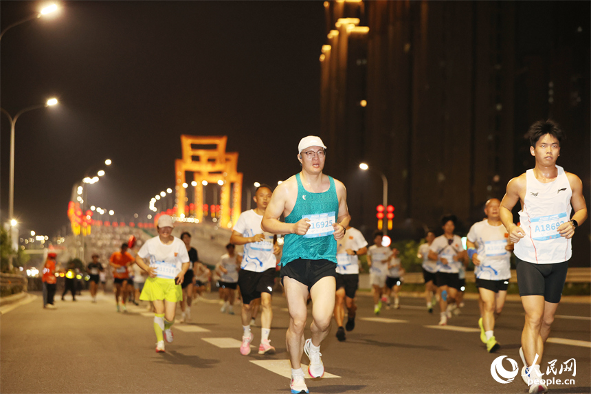 2026南昌万人夜跑活动30日晚鸣笛开跑。图为跑友奔跑在洪州大桥上。人民网记者 时雨摄