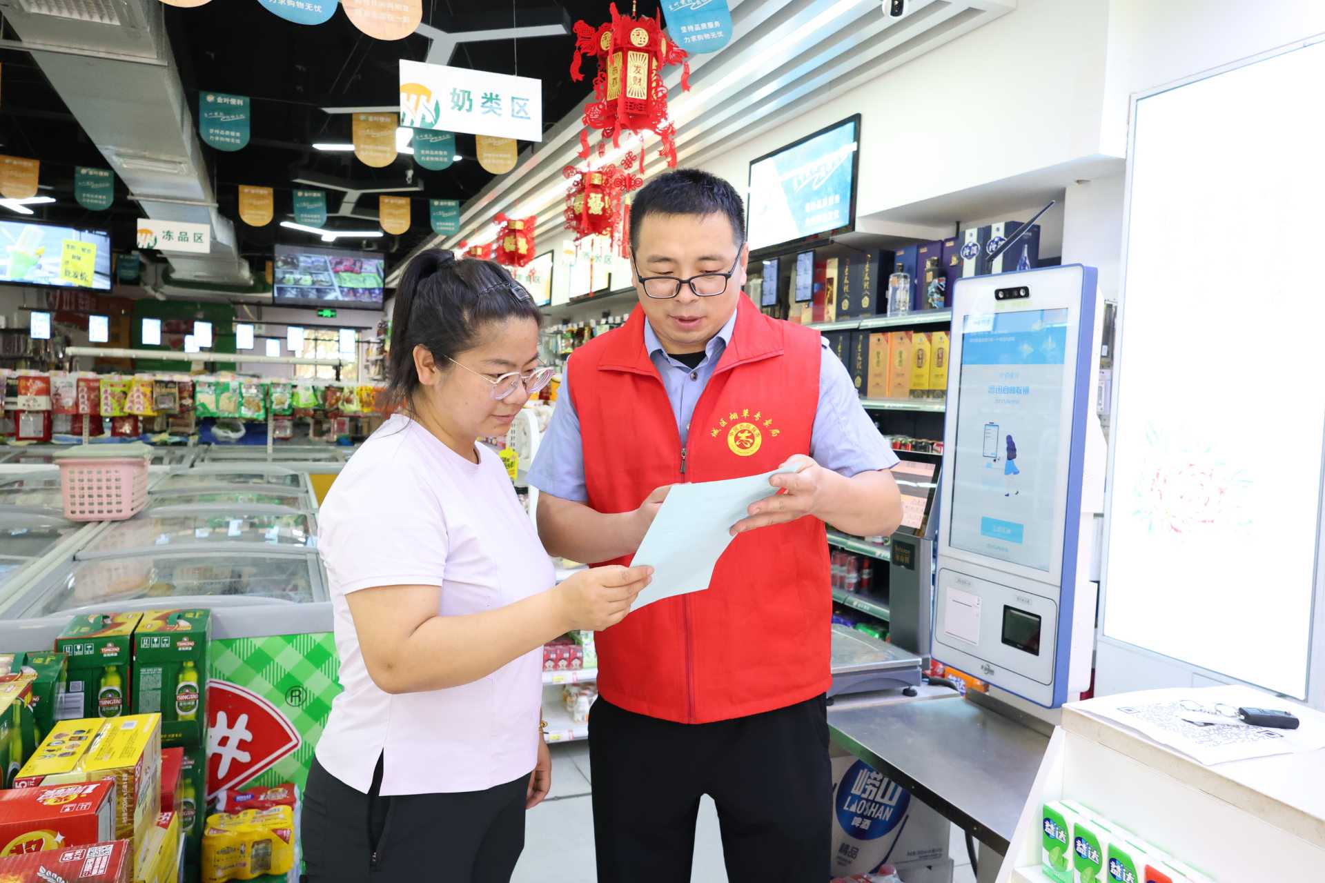 1780901965687524.jpg 图为市场监管员为辖区商户宣传法律法规.jpg