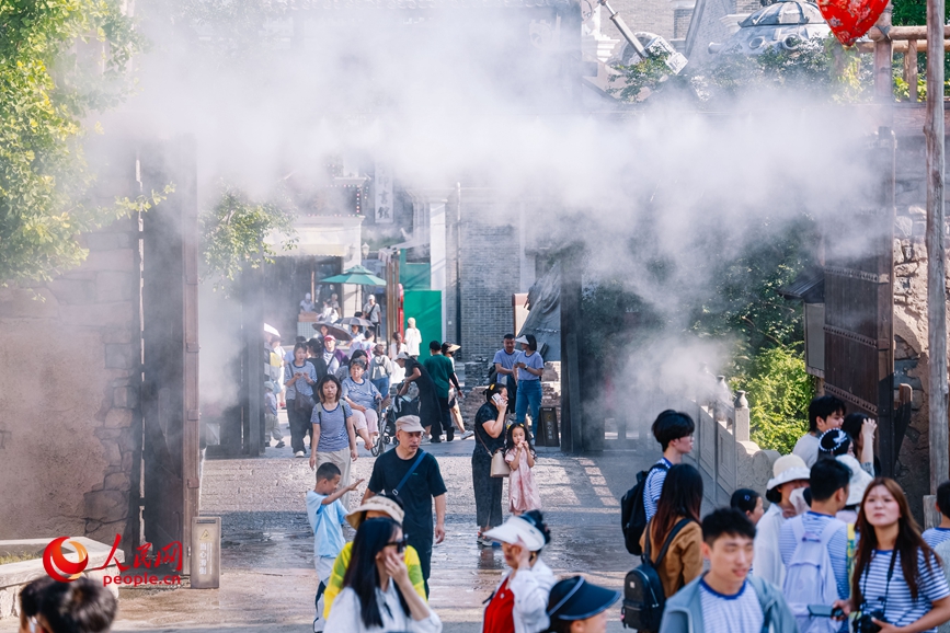郑州电影小镇开启雾森降温装置,丝丝水雾驱散暑气。人民网记者 辛静摄