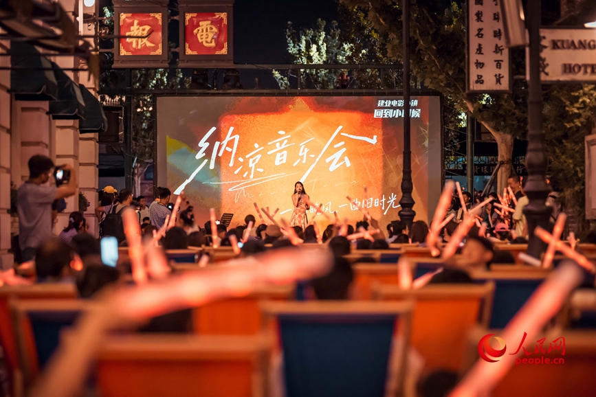 郑州电影小镇内,游客坐在躺椅上惬意听音乐会。人民网记者 辛静摄