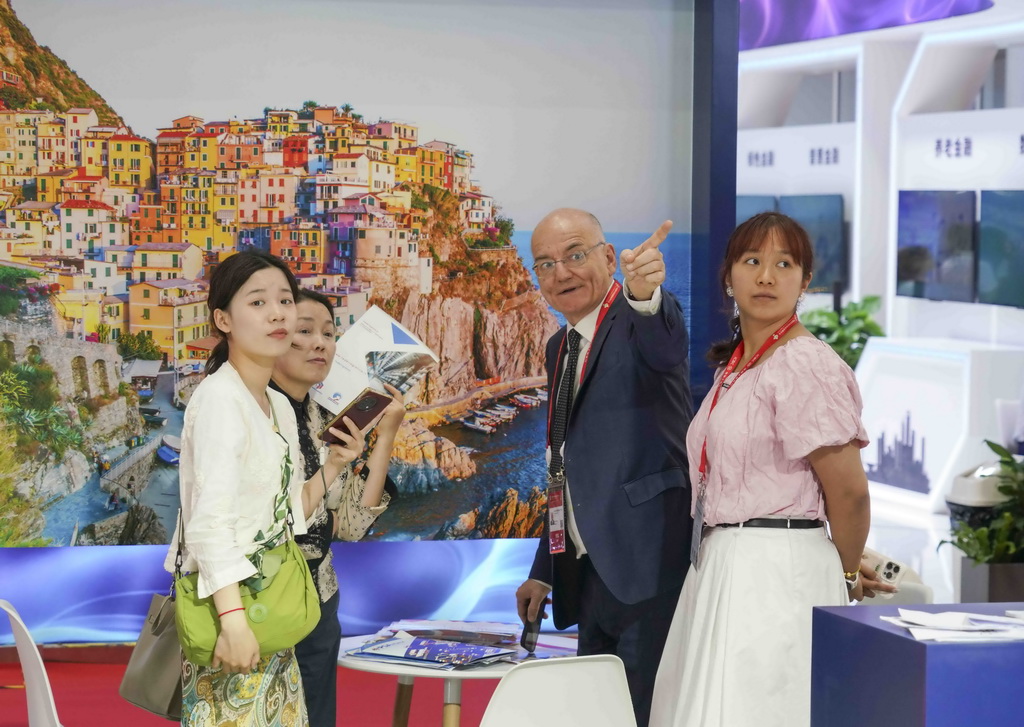 6月24日，观众在链博会供应链服务展区的意大利利古里亚大区主宾馆展台与工作人员交流。新华社记者 肖恩楠 摄