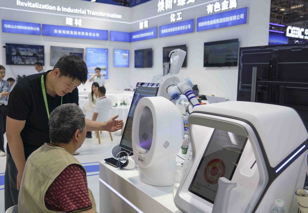 6月24日，工作人员在链博会清洁能源链展区的安徽省主题形象展台引导参观者体验一款AI辅助诊断系统。新华社记者 肖恩楠 摄