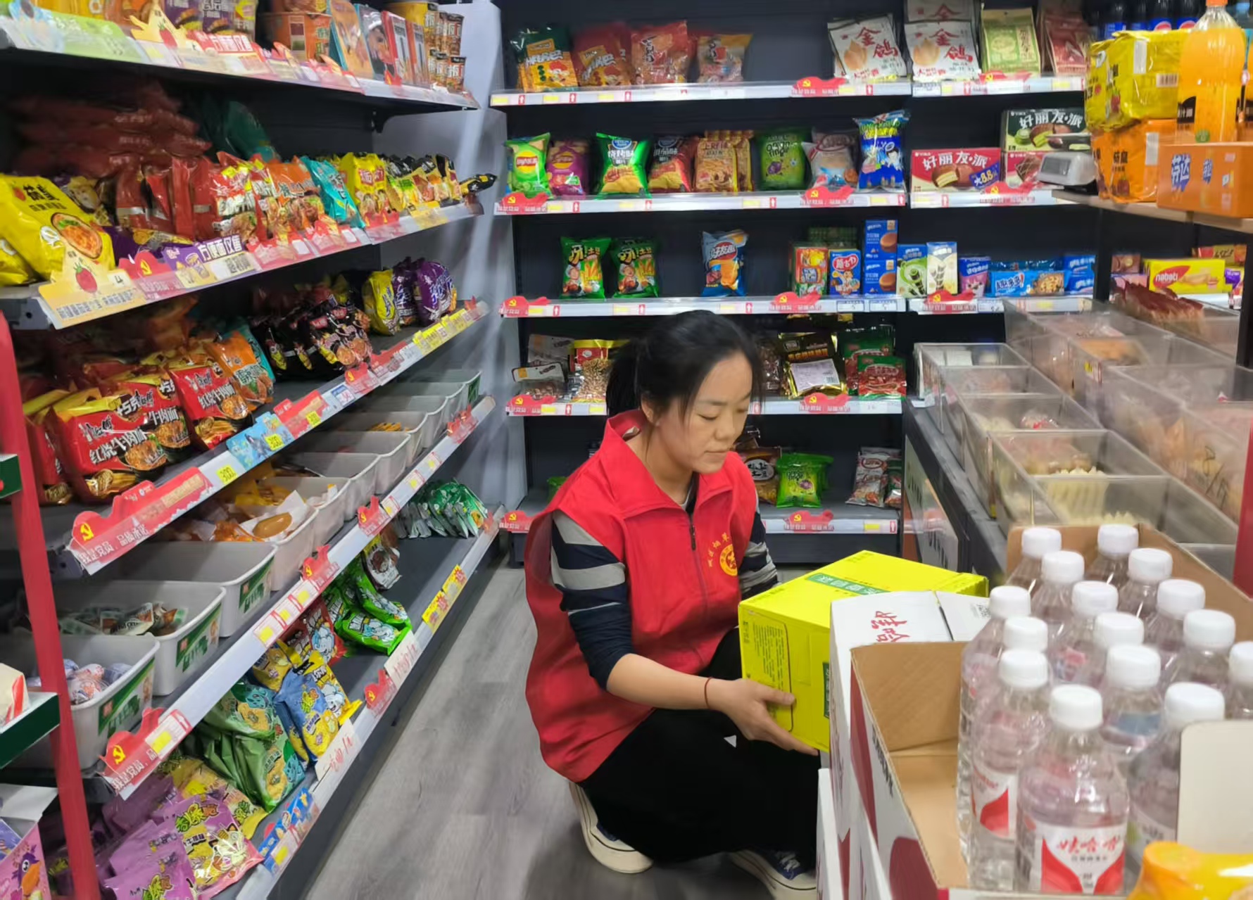 图为市场监管员为商户整理货架.jpg