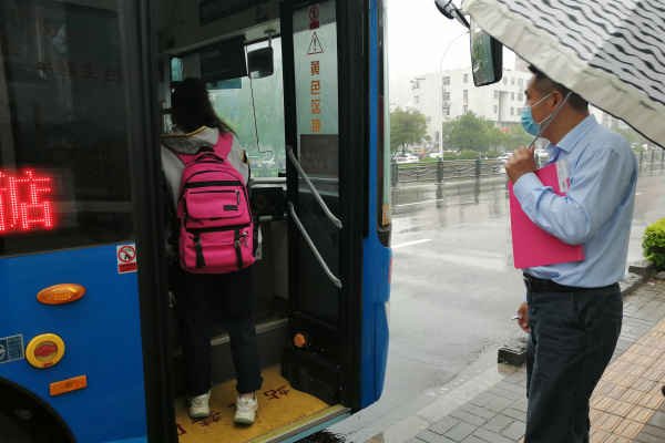 1791601997933235.jpg 2、志愿者冒雨将孩子送上回家的公交车.jpg